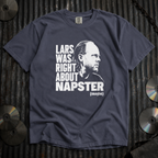A dark slate blue graphic t-shirt laid flat on a corrugated metal background, featuring a black and white portrait of Lars Ulrich and the text 'LARS WAS RIGHT ABOUT NAPSTER (maybe)'.